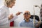 mature blond woman ophthalmologist and a happy man retired eyesight check