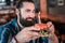 Mature blue-eyed man looking at cute burger with birthday candle