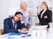 Mature boss is chastising employees because of uncompleted work