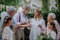 Mature bride and groom toasting with family at wedding reception outside in the backyard.