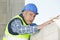 Mature builder man holding concrete blocks for house building