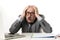 Mature business man with bald head on his 60s working stressed and frustrated at office computer laptop desk looking desperate