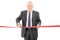 Mature businessman cutting a red tape