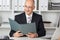 Mature Businessman Holding File At Office Desk