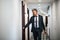 Mature businessman with luggage in a hotel corridor.