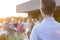 Mature businessman pouring wine from bottle for colleagues during rooftop party