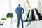 Mature businessman standing in front of escalators in modern office