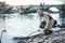 Mature businessman standing by river Vltava in Prague city, feeding a swan.