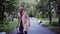 Mature businessman with suitcase walking in a park in a city, checking the time.