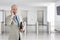 A mature businessman talking on his cell phone in a modern office building lobby. Horizontal format with copy space