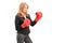 A mature businesswoman with red boxing gloves ready to fight