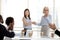 Mature businesswoman shaking hand of employee at company briefing