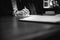 Mature Caucasian male is sitting at a desk in a professional setting, signing a document