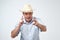 Mature caucasian man in cowboy hat making a sign with fingers like he is shooting ahead.