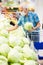 Mature caucasian man in mask with covid protection choosing head of cabbage in vegetable section of supermarket