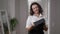 Mature Caucasian woman admiring graduation cap standing at home indoors. Portrait of intelligent motivated lady getting