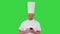 Mature chef in white uniform texting a message on his cellphone on a Green Screen, Chroma Key.