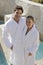 Mature Couple In Bathrobe Standing By Pool