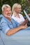 Mature Couple Enjoying Road Trip In Classic Open Top Sports Car Together