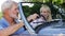 Mature couple enjoying road trip in classic open top sports car together