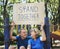 Mature couple holding a stand together signboard