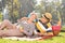 Mature couple listening music on a picnic in park