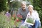 Mature Couple Planting Out Plants In Garden