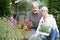 Mature Couple Planting Out Plants In Garden