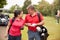 Mature Couple Playing Round Of Golf Carrying Golf Bags And Marking Scorecard