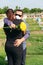 Mature couple with protective mask in cemetery embracing during burial. Death, cemetery, loss of loved ones due to pandemic