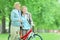 Mature couple pushing a bicycle in park