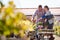 Mature Couple Pushing Trolley With Plants They Have Bought At Garden Center