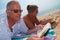 Mature couple reading on beach