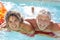 Mature Couple Relaxing On Airbed In Swimming Pool