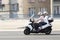 Mature couple riding on a three wheels motorbike and a woman is looking at her wrist watch