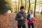 Mature Couple Running Through Autumn Woodland Together