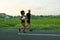 Mature Couple Running On Road At Tropical Landscape. Caucasian Man And Asian Woman On Jogging Workout.