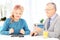 Mature couple seated on table playing dominos at home