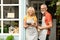 Mature couple small business owners standing at entrance door to their bar