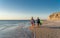 Mature couple surfers with surfboard having fun on empty remote beach enjoying outdoors lifestyle