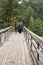 Mature couple walking on the wooden bridge. Casual wear. True l