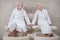 Mature couple in white robes having a hydromassage for feet and feeling great