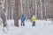 Mature couple in winter sportswear are skiing in snowy forest