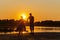 Mature couples dance on a wild beach in the rays of the setting sun on a summer evening