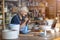 Mature craftswoman painting a plate made of clay in art studio