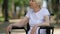 Mature disabled woman crying sitting in wheelchair outdoor, loneliness, closeup