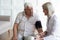 Mature doctor cardiologist checking older man blood pressure during visit