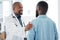 Mature doctor giving a patient support. African american doctor touching a patient on the arm. Patient in a consult with