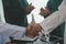 Mature doctors and young nurses stacking hands together at hospital. Close up hands of medical team stacking hands. Group of