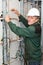 Mature electrician working in hard hat with cables